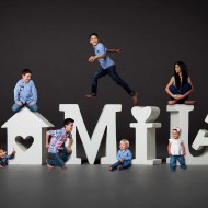Creative Family Portrait with Children jumping and gathering around large letters that spell family.