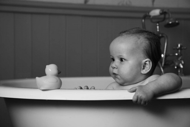 Baby in a bath with a duck by Eric Pearce photography