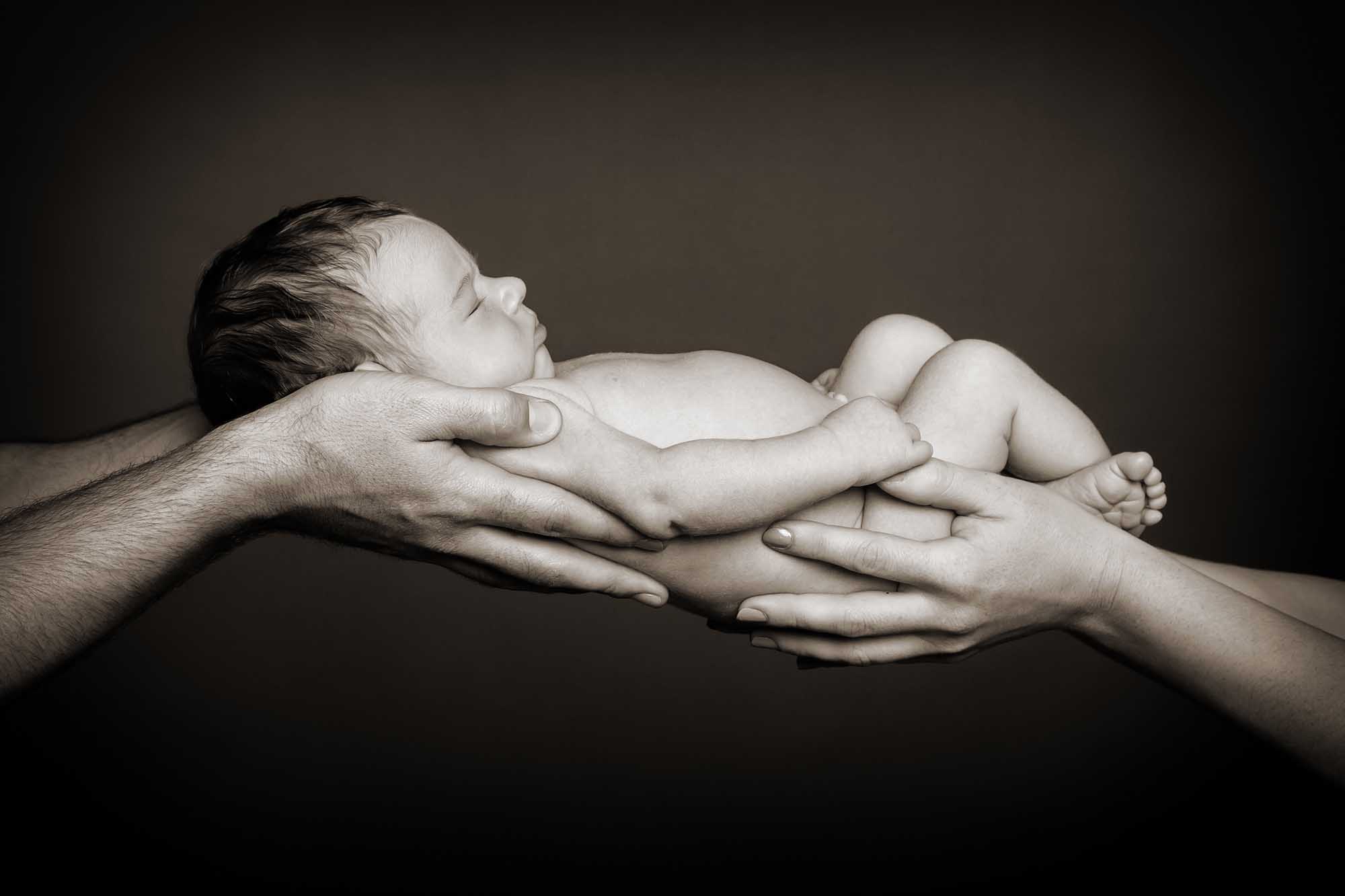 New baby in parents' hands by Eric Pearce Photography